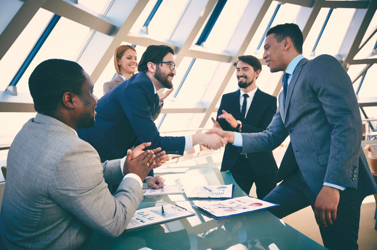 Co-Investing and Direct Deals - group of young professionals shaking hands and making a deal